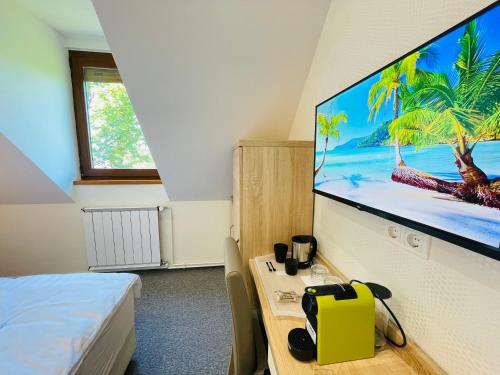 um quarto com uma televisão numa parede com uma mesa em Mikes Deluxe Home em Balatonfüred