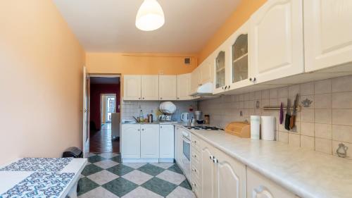 a kitchen with white cabinets and a checkered floor at roomspoznan pl - Rybaki 15 - 24h self check-in in Poznań
