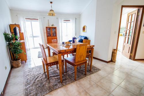 a dining room with a wooden table and chairs at Lighthouse North Villa - Praia da Barra in Praia da Barra