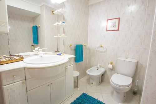 a bathroom with a sink and a toilet and a mirror at Lighthouse North Villa - Praia da Barra in Praia da Barra