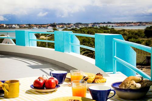 a table with food and drinks on a balcony at Lighthouse North Villa - Praia da Barra in Praia da Barra