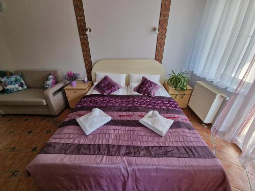 sypialnia z fioletowym łóżkiem z poduszkami i kanapą w obiekcie Apartament Hexagon nr 14 w Grzybowie