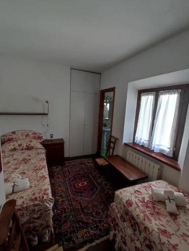 a hotel room with two beds and a window at Appartamento Belvedere Abetone in Abetone