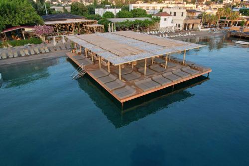 a dock with a building on top of the water at Faros Bodrum Hotel - Special Category in Golturkbuku