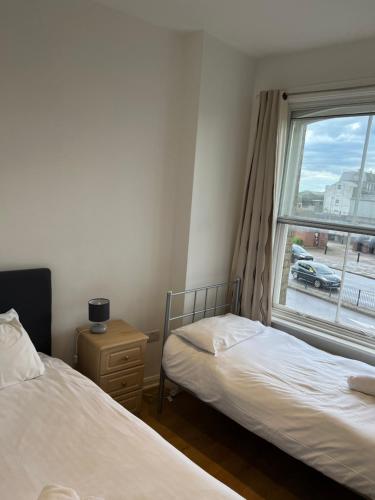 two beds in a room with a window at Entire Flat With View to River Yare, H 1 in Great Yarmouth