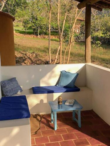 a porch with two blue cushions and a table at Finca San Pedro in Barichara