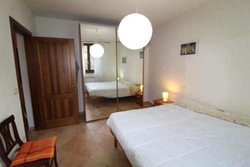 ein Schlafzimmer mit einem Bett und ein Zimmer mit einem Spiegel in der Unterkunft Bellavista apartment 20 minutes from sea/beaches in Giuncarico