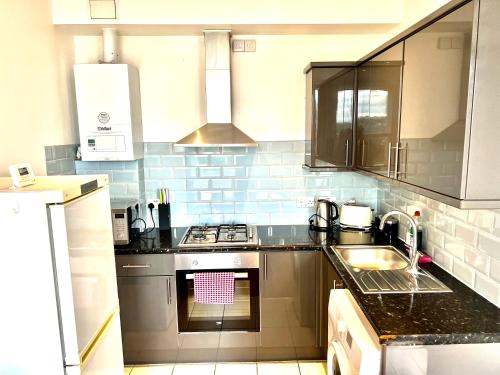 uma cozinha com um lavatório e um fogão forno superior em Entire Flat With View to River Yare, H 1 em Great Yarmouth