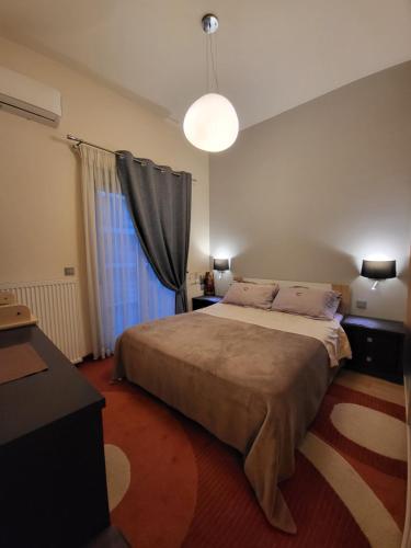Un dormitorio con una cama grande y una ventana en Cozy apartment in front of the park en Athens