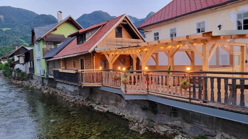 a row of wooden buildings next to a river at Captain's Lodge in Bohinj