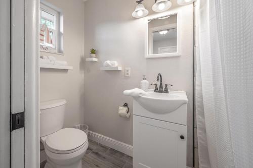 een witte badkamer met een toilet en een wastafel bij Upgraded Seminole home in a quiet neighborhood in Seminole