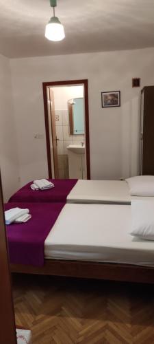 a bedroom with a large bed and a mirror at DVOKREVETNA SOBA SA KUPAONICOM in Vodice