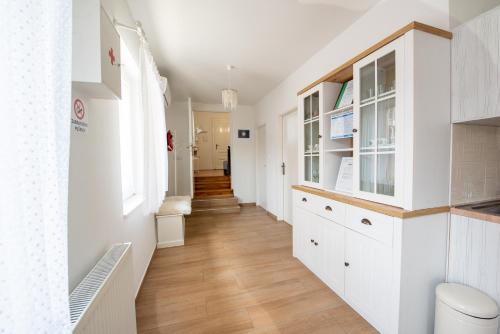 a hallway with white cabinets and wood floors at Holiday House GoodLife - Family & Friends in Požega