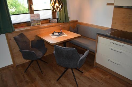a kitchen with a table and two chairs and a counter at Ramseiderhof in Saalfelden am Steinernen Meer