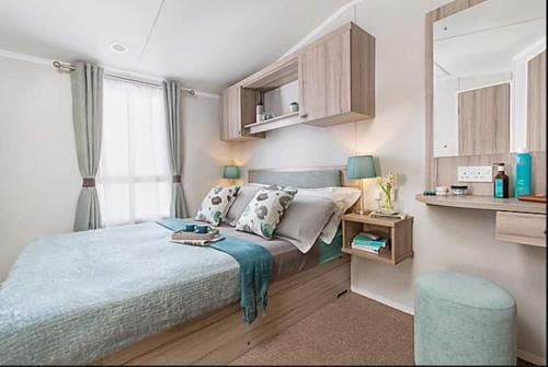 um quarto com uma cama grande e um cobertor azul em St Andrews Holiday Home Walk to the Old Course em St. Andrews