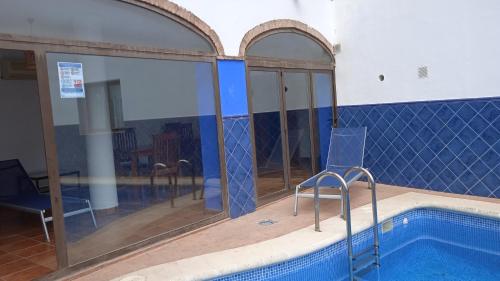 a swimming pool in a building with a blue tiled wall at Hotel Rural La Posada de las Cigüeñas in Jerez de los Caballeros