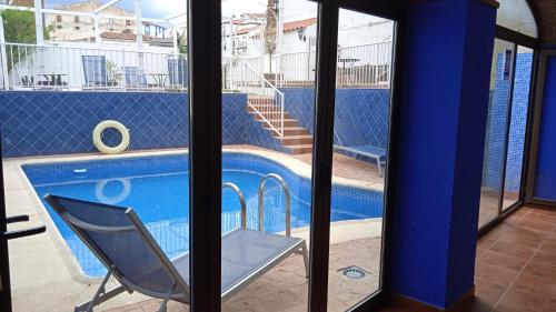 a chair sitting in front of a swimming pool at Hotel Rural La Posada de las Cigüeñas in Jerez de los Caballeros