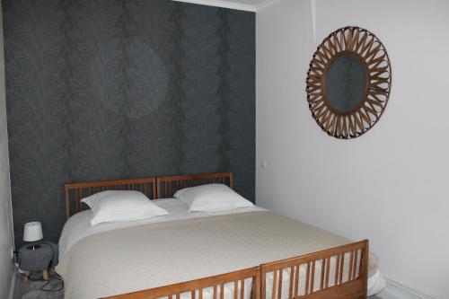 um quarto com uma cama e um espelho na parede em Dans maison de charme, bel appartement privatif em Saint-Laurent-de-Brévedent
