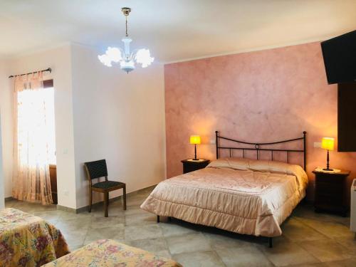 a bedroom with two beds and a chandelier at Agriturismo CuoreLieto del Cilento in Corleto Monforte