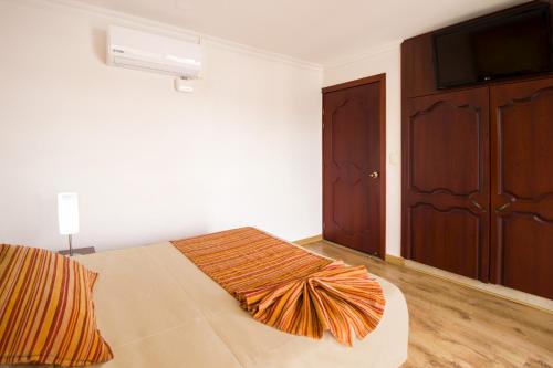 a bedroom with a bed and a flat screen tv at Hotel Luxor Pereira in Pereira