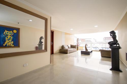 a living room with a large mirror on the wall at Hotel Luxor Pereira in Pereira