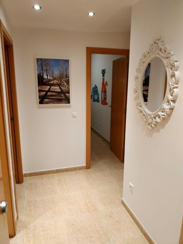 a hallway with a mirror on a white wall at Mi Apartamento en el Delta del Ebro in Deltebre