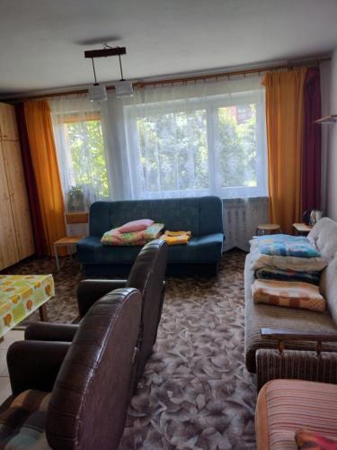 Willa Rosa في تشيخوتشينيك: غرفة معيشة مع أريكة زرقاء ونوافذ