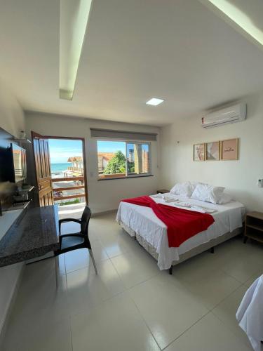 a bedroom with a bed and a chair and a balcony at Pousada e Restaurante Altas Horas Beach in Itapipoca