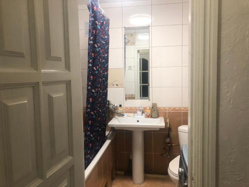 un bagno con lavandino, WC e specchio di Квартира Пентагон a Korostenʼ