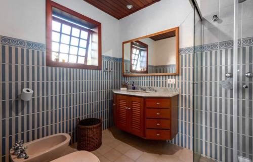 uma casa de banho com uma banheira, um lavatório e um espelho. em Suítes Villa Panorama em Campos de Jordão