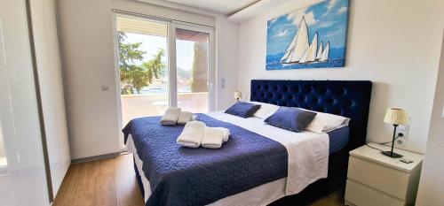 a bedroom with a blue bed with towels on it at Aquamarine Deluxe Apartment in Dubrovnik