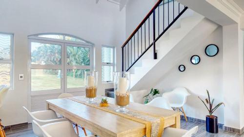 a dining room with a wooden table and white chairs at Caribbean Estate Supreme by Top Destinations Rentals in Port Edward