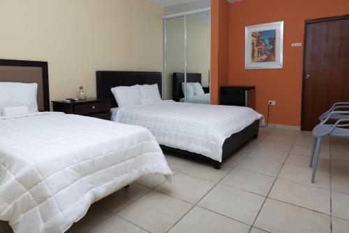 una camera d'albergo con due letti e un tavolo di Red Sunset Beach Club a Boquerón