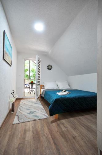 a bedroom with a bed with a blue bedspread at Stil Park Apartmani in Vrnjačka Banja