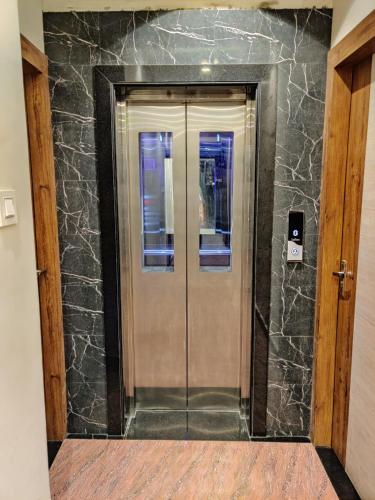 a elevator in a building with a stone wall at Hotel City Palace in Varanasi