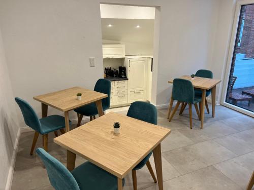 jadalnia ze stołami i krzesłami oraz kuchnia w obiekcie Haus Antina w mieście Borkum