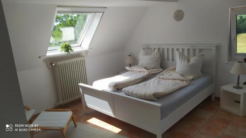 Bett in einem weißen Zimmer mit Fenster in der Unterkunft Aparthotel & Wohnungen am Norderteich in Horn-Bad Meinberg