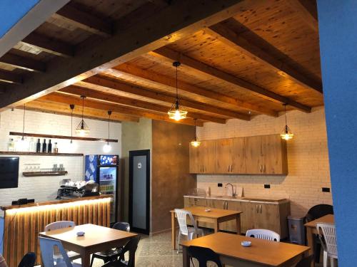 ein Restaurant mit Holztischen und -stühlen und einer Küche in der Unterkunft Rittson - Boutique Hotel in Vlorë