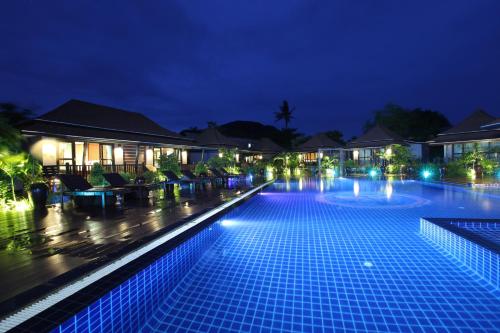 a large swimming pool at night with lights at Ibiza House Phi Phi in Phi Phi Don