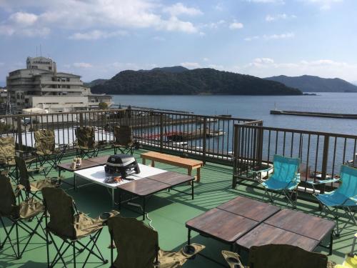 a deck with tables and chairs and the water at HARBOR TERRACE RYUGATAKE - Vacation STAY 28730v in Takakushi