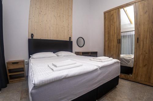 a bedroom with a large white bed with a mirror at Ecopark Tuzlata Екопарк Тузлата in Balchik