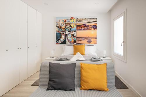 a bedroom with a large bed with yellow pillows at Aveiro CityVenice in Aveiro