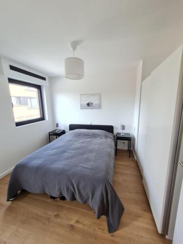 Un dormitorio con una cama grande y una ventana en Vakantiehuis Mariakerke, en Ostende