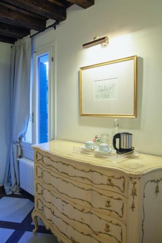 a bathroom with a dresser in a room with a window at Ca Spada 2 Bedrooms & 2 Bathrooms Venice Apartment in Venice