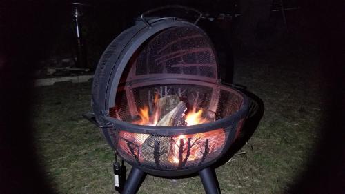 a fire in a grill in the yard at night at Secluded Glamping in Oley Valley 