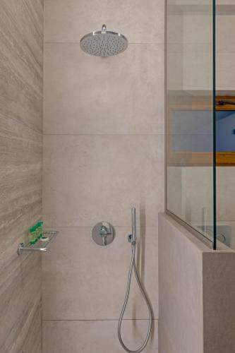 a shower with a shower head in a bathroom at Viva Mare Studios in Astypalaia Town