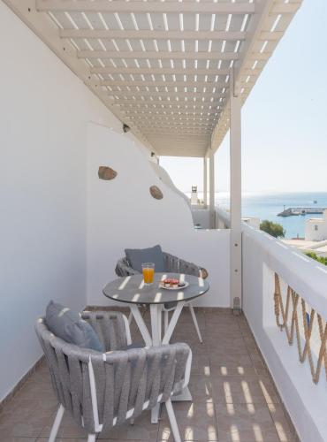 a balcony with a table and chairs and the ocean at Viva Mare Studios in Astypalaia Town