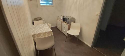 a room with a table and two chairs and a television at Chambre d'hôte L'optimisme in Montfaucon