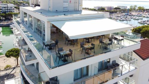 an aerial view of a building with tables and chairs on the balcony at Hotel Mare in Lignano Sabbiadoro