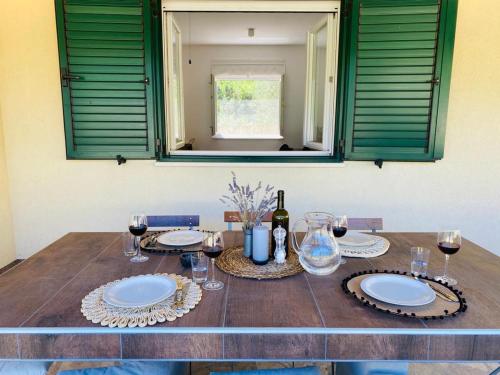 a table with plates and glasses of wine on it at Casa Mediteran in Stomorska